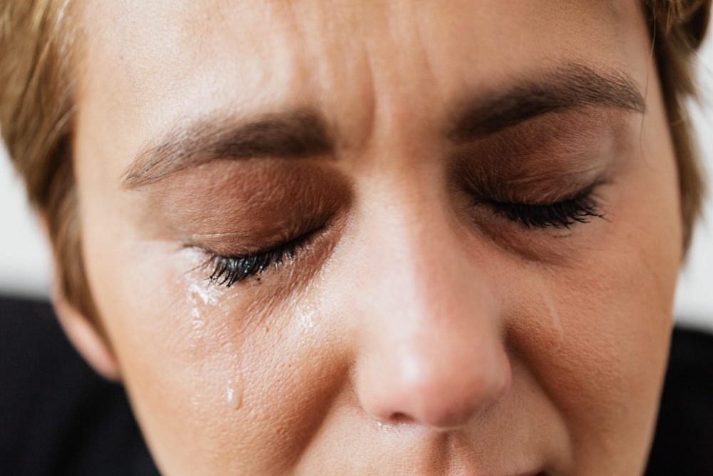 Uma mulher chorando pois não sabe mais o que fazer na sua vida.